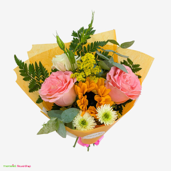 Bonito ramillete con rosas rosadas de Ecuador, girasol, lisianthus, follaje y solidago, fotografiado desde arriba